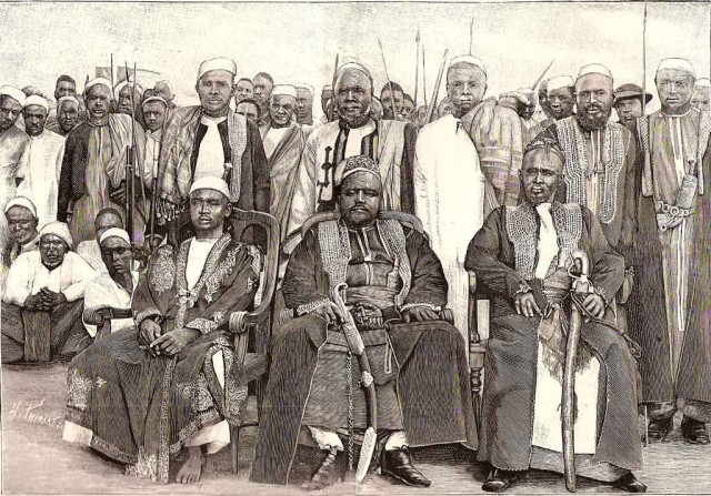 Tsialana, roi de Nossi-Mitsiou, sa famille et sa suite. A sa droite, son fils Tsiharon, à sa gauche son frère Fahavana. Gravure parue dans L’Illustration du 16 août 1890